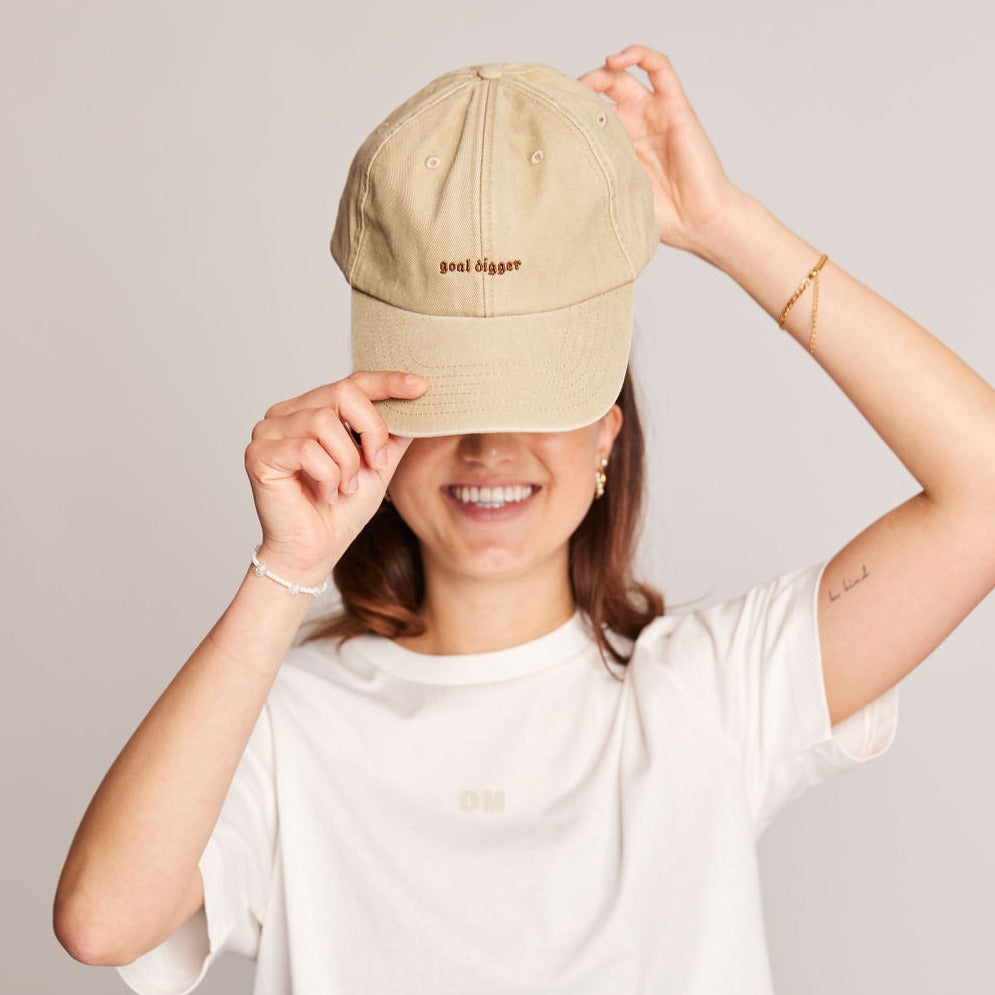 beige kappe mit stick "goal digger" in dunkelbraun von person getragen