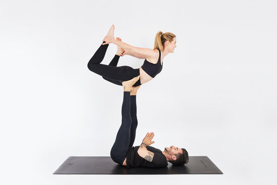 Zwei Personen praktizieren Yoga auf einer one mantra Yogamatte schwarz 4mm